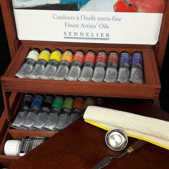 Une boîte avec un tiroir qui contient des tubes de peinture