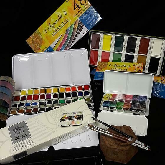 Plusieurs palettes de peinture posées sur une table