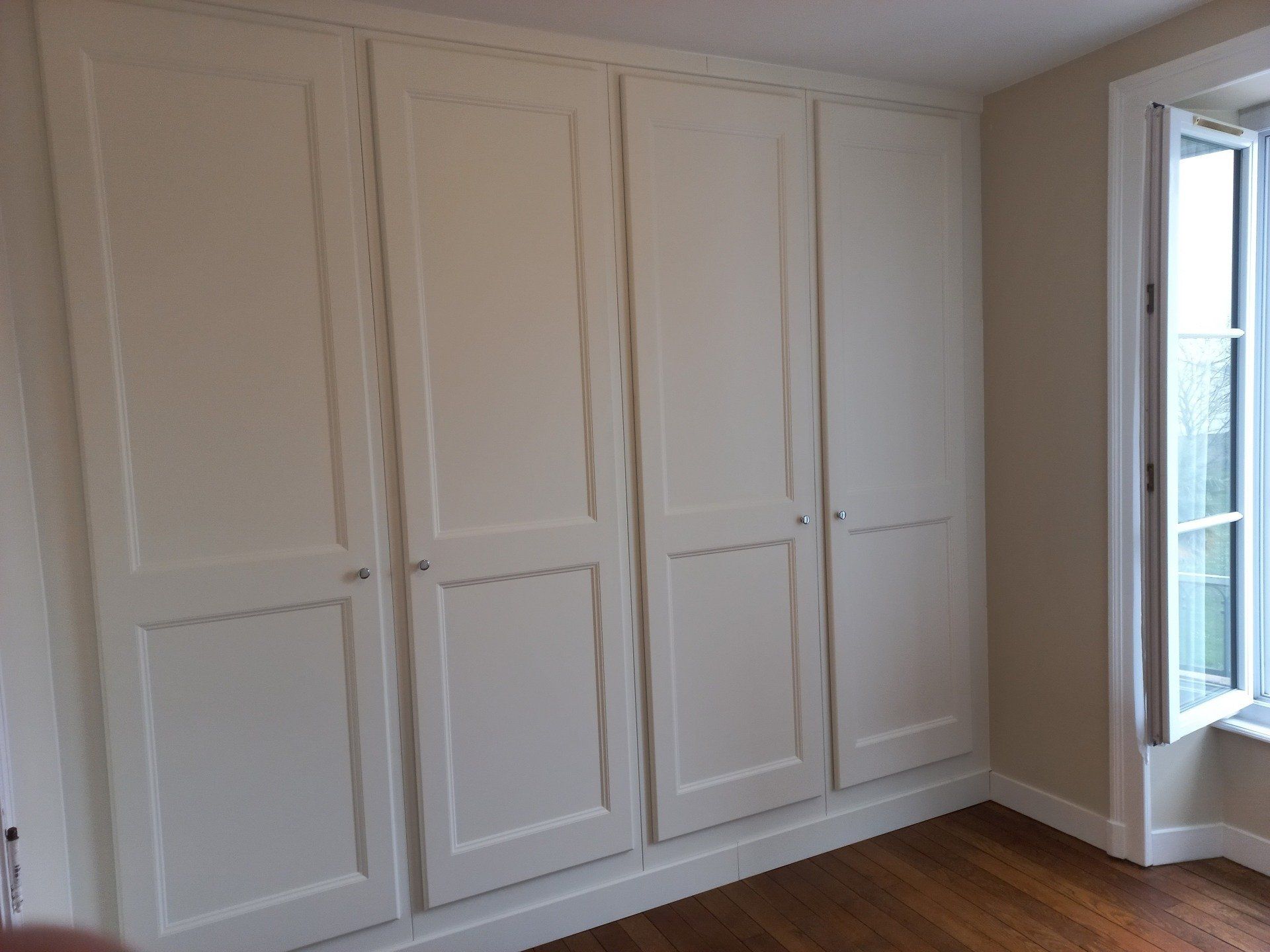 Plusieurs portes fermées d'un placard encastré dans le mur