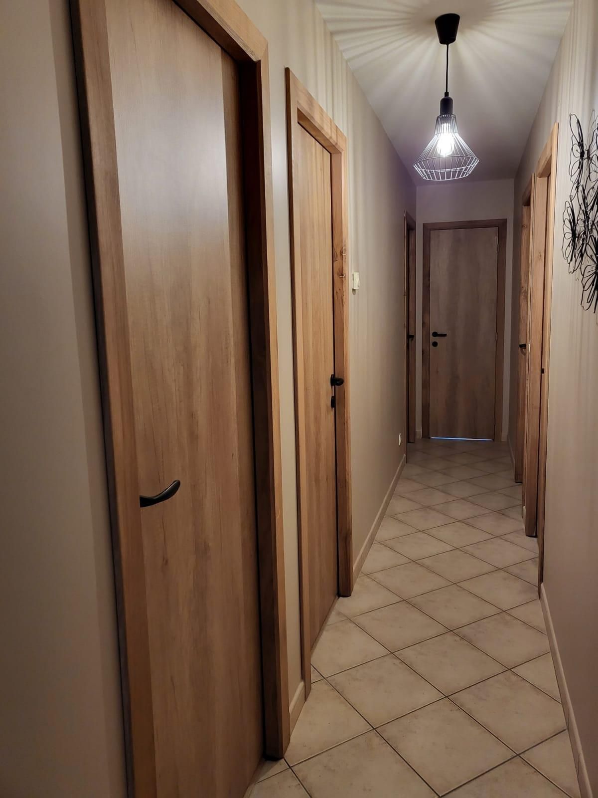 Plusieurs portes en bois fermé de chaque côté des murs dans un couloir