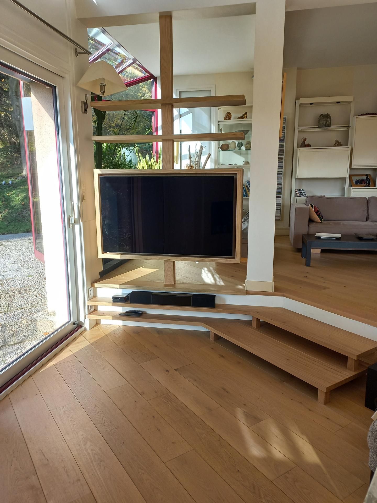 Télévision posée sur un rebord à côté d'un petit escalier