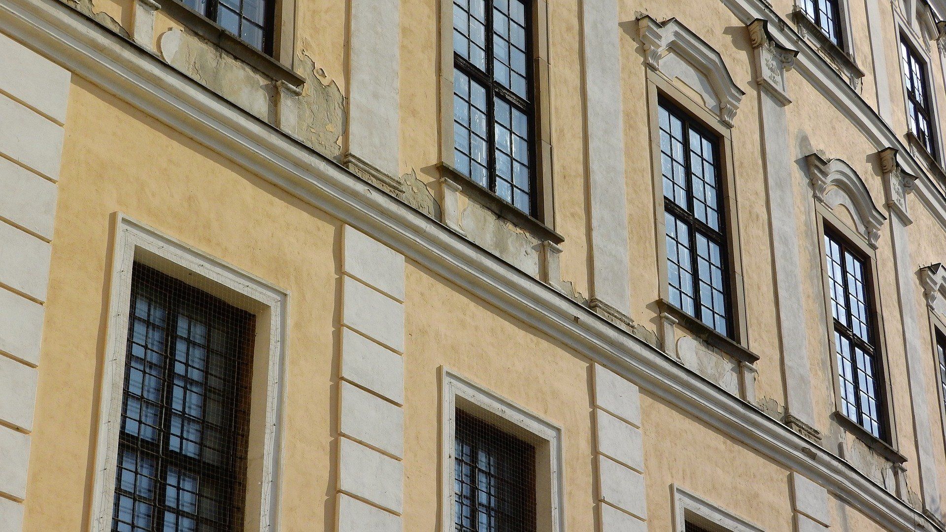 Vue du dessous de la façade d'un immeuble à plusieurs fenêtres sur chaque étage