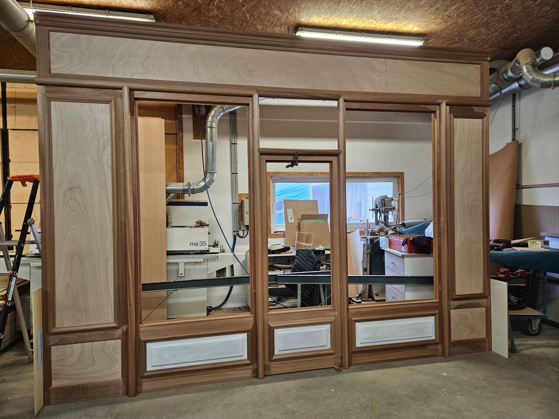 Conception en bois d'une façade avec porte et de fenêtres dans un atelier