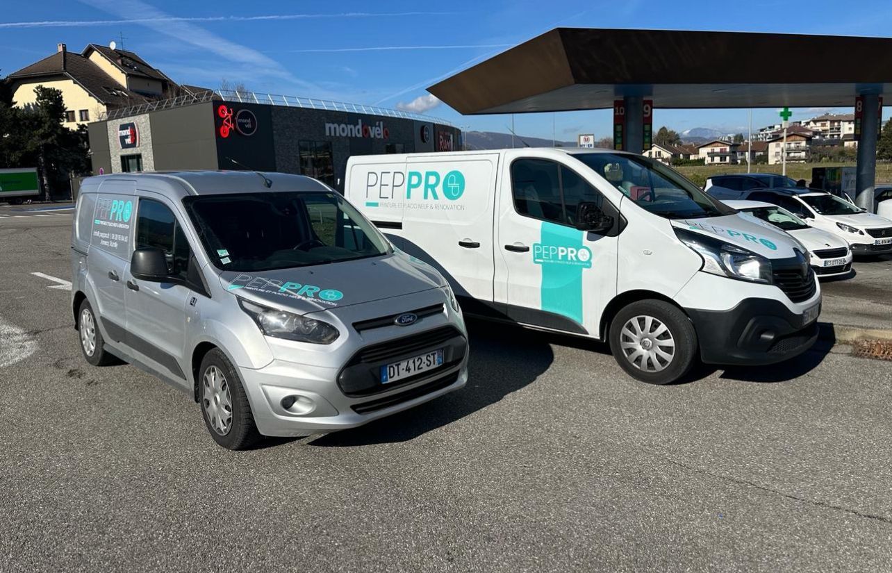 Photo prise sur le côté de deux camionnettes floquées au nom et au logo de l'entreprise PEP PRO