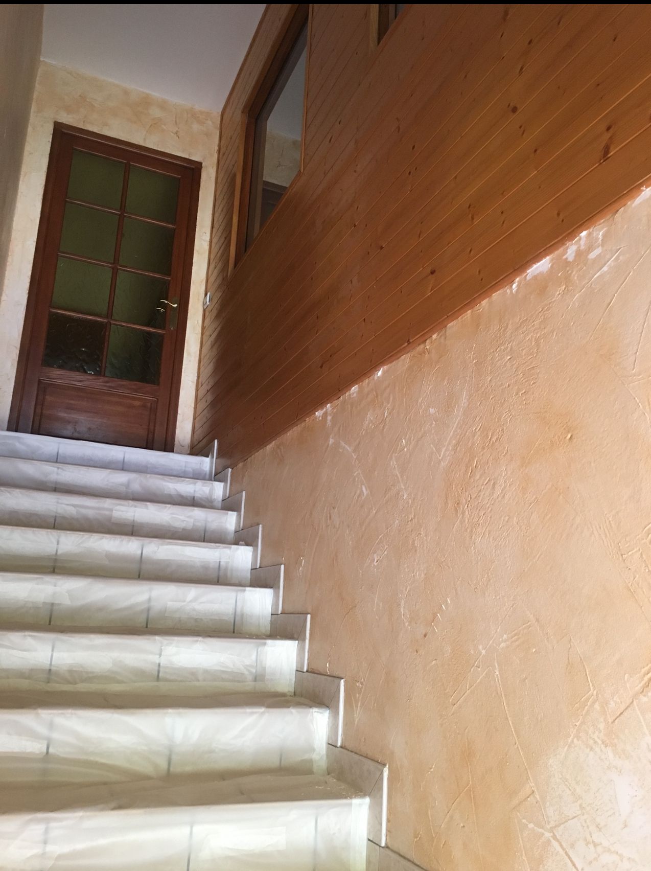 Photo d'un escalier avant la restauration des murs.