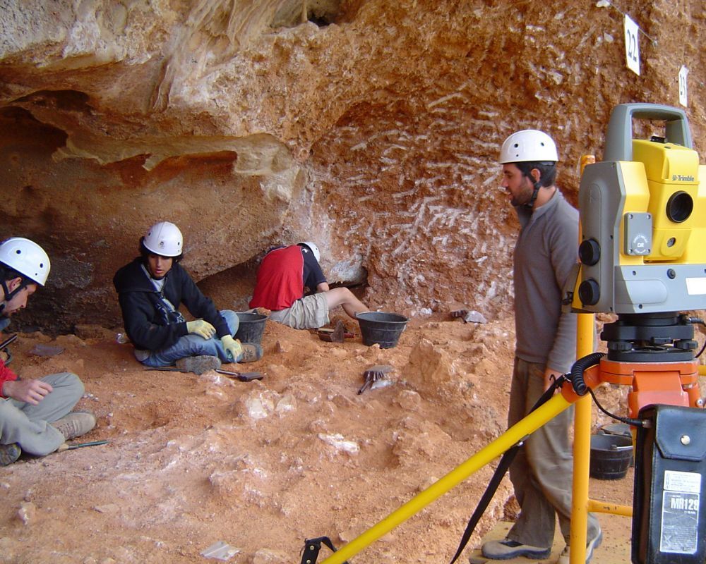 Un hombre está de pie junto a un dispositivo Leica amarillo.
