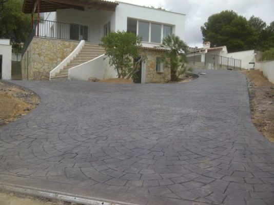 Un camino de entrada que conduce a una gran casa blanca con escaleras.