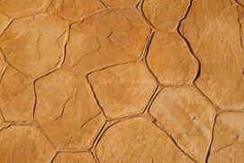 Un primer plano de una pared de piedra marrón con un patrón geométrico.