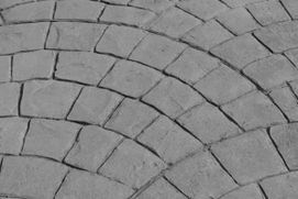 Un primer plano de un piso de ladrillo con un patrón circular.