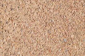 Un primer plano de una superficie arenosa con muchas rocas pequeñas sobre ella.