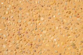 Un primer plano de una superficie arenosa con pequeñas rocas sobre ella.