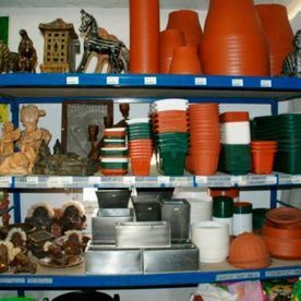 Estanterías repletas de macetas de terracota y objetos decorativos, variedad de tamaños y estilos.