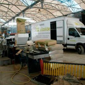 Un camión blanco de Ellzalde cargando bolsas en una fábrica.
