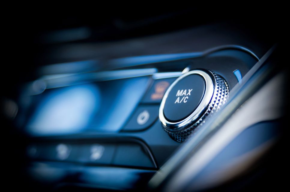 Gros plan sur le bouton de commande de climatisation d'un tableau de bord de voiture.