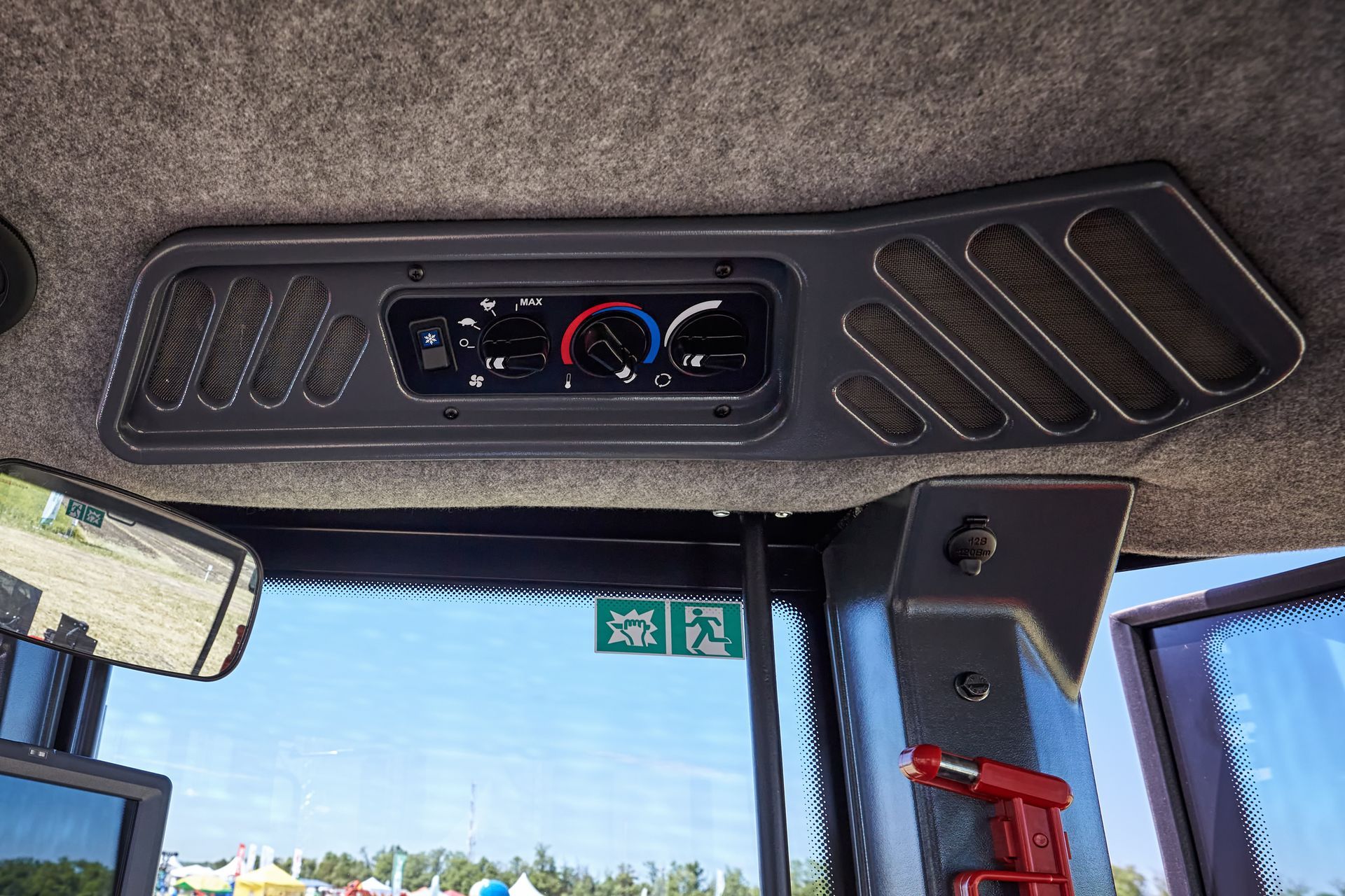 À l'intérieur de la cabine d'un tracteur, vue sur le panneau de réglage de la climatisation.