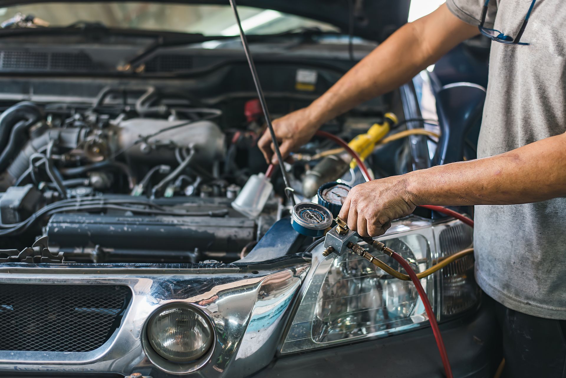 Un mécanicien vérifie le circuit de climatisation d'une voiture.