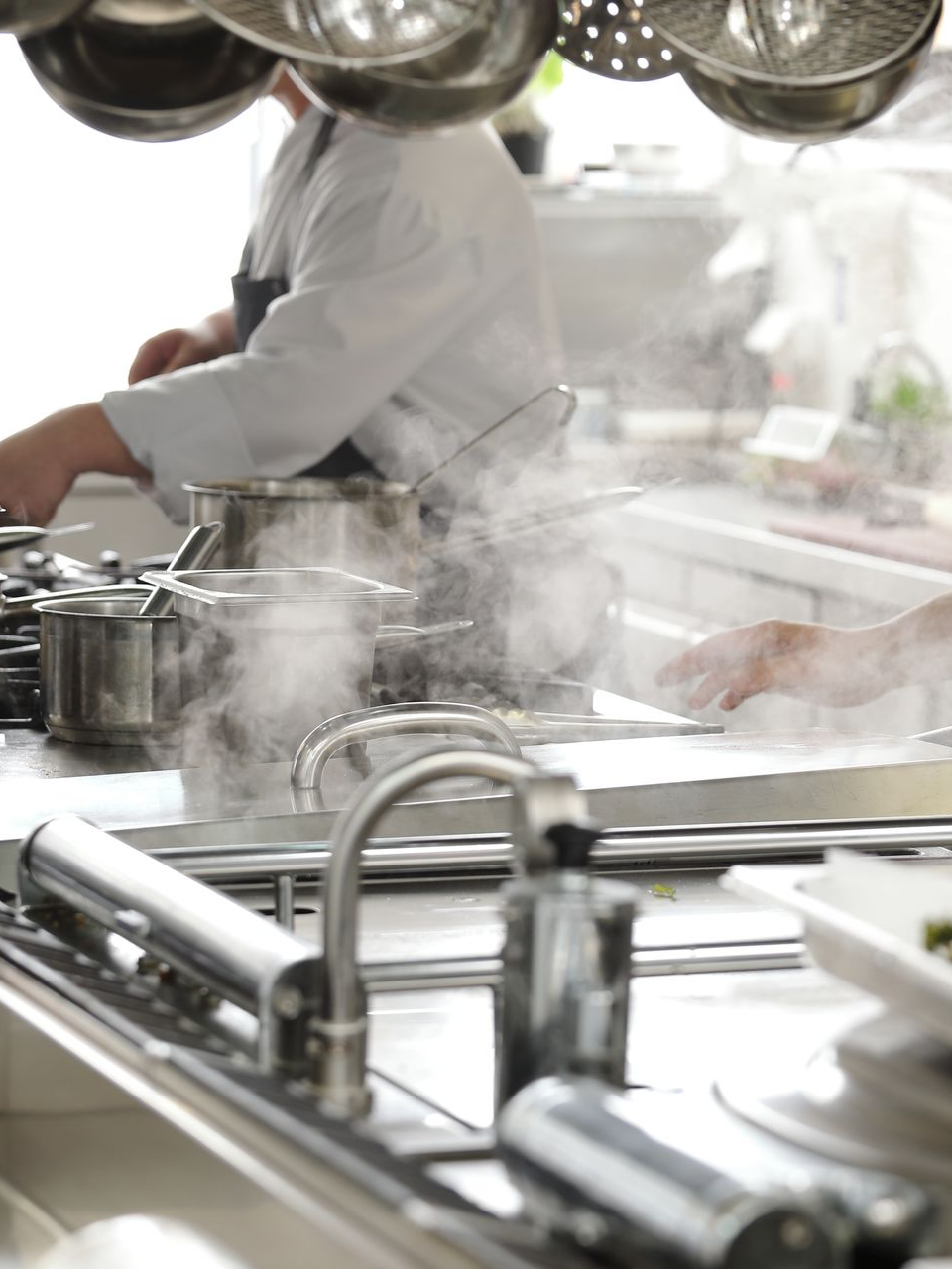 Un chef cuisine dans une cuisine professionnelle.