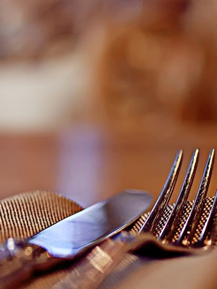 Fourchette et couteau sur une serviette texturée. 