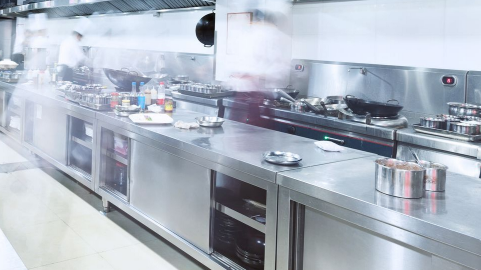 Cuisine professionnelle avec de la vapeur s'échappant des plaques de cuisson.