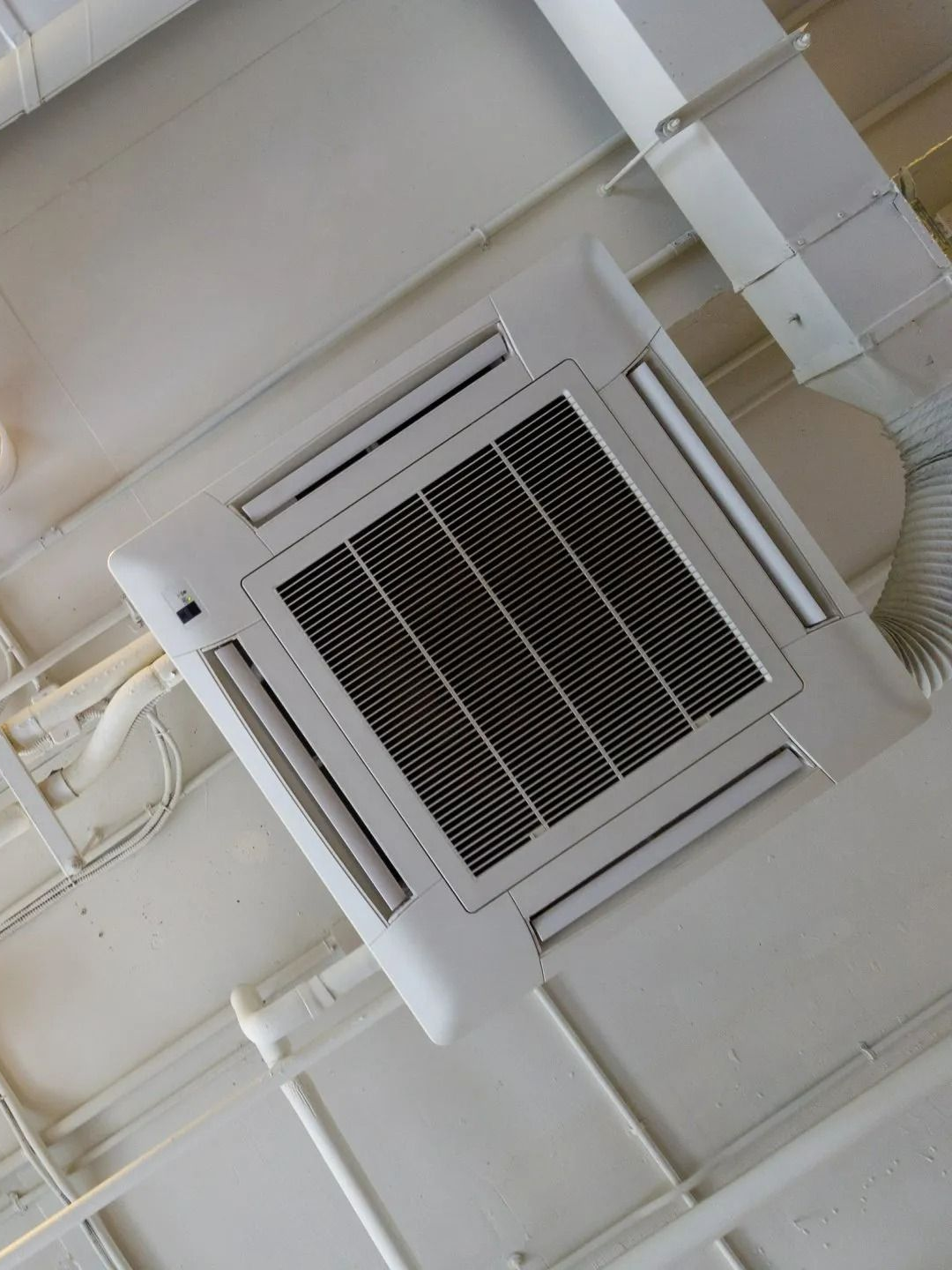 Climatiseur de plafond avec grilles d'aération.