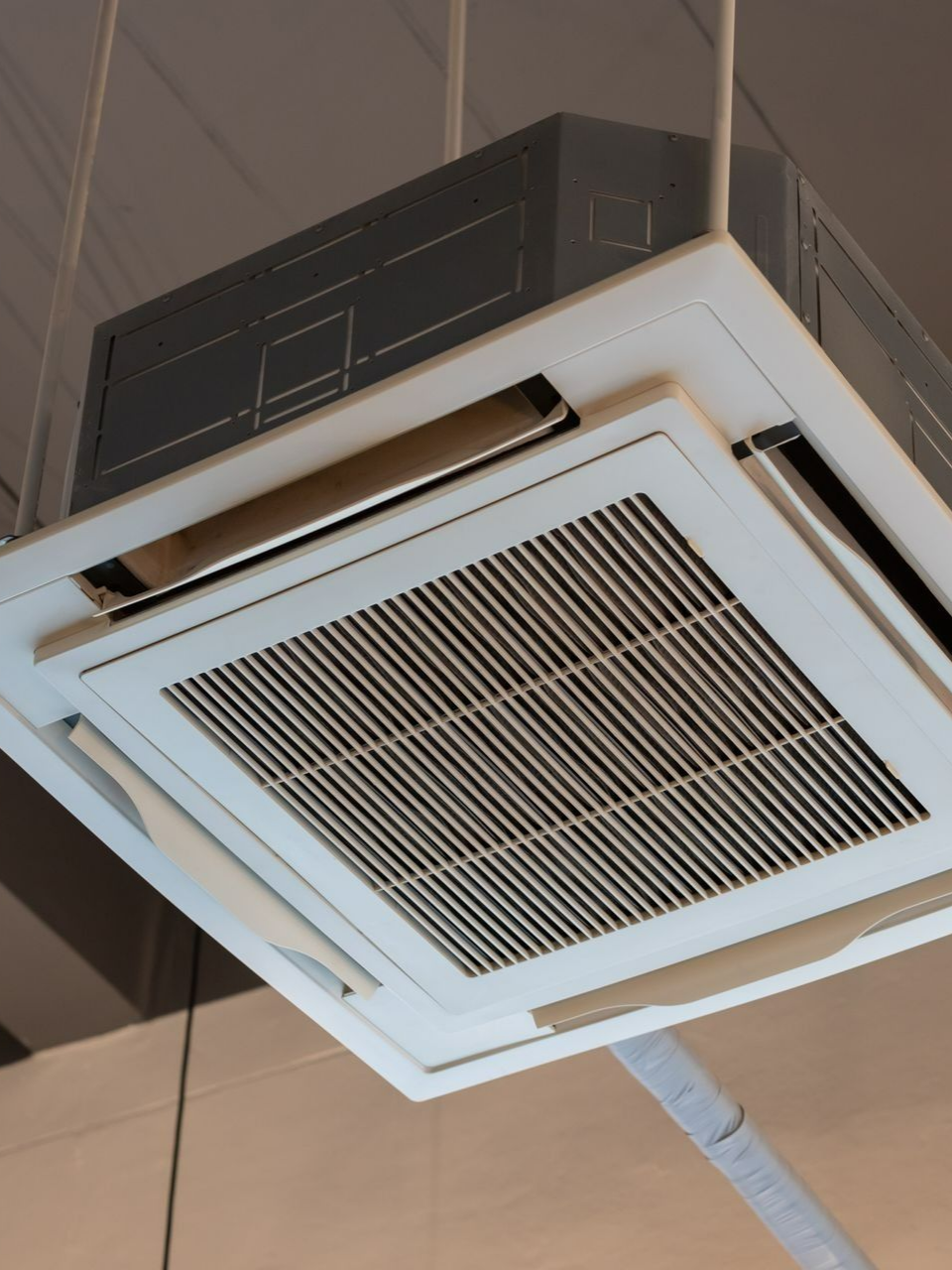 Climatiseur de plafond avec grilles d'aération.