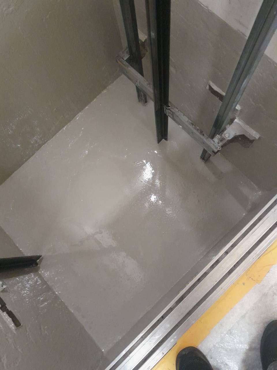 Surface gris clair avec supports métalliques, évoquant un environnement industriel.