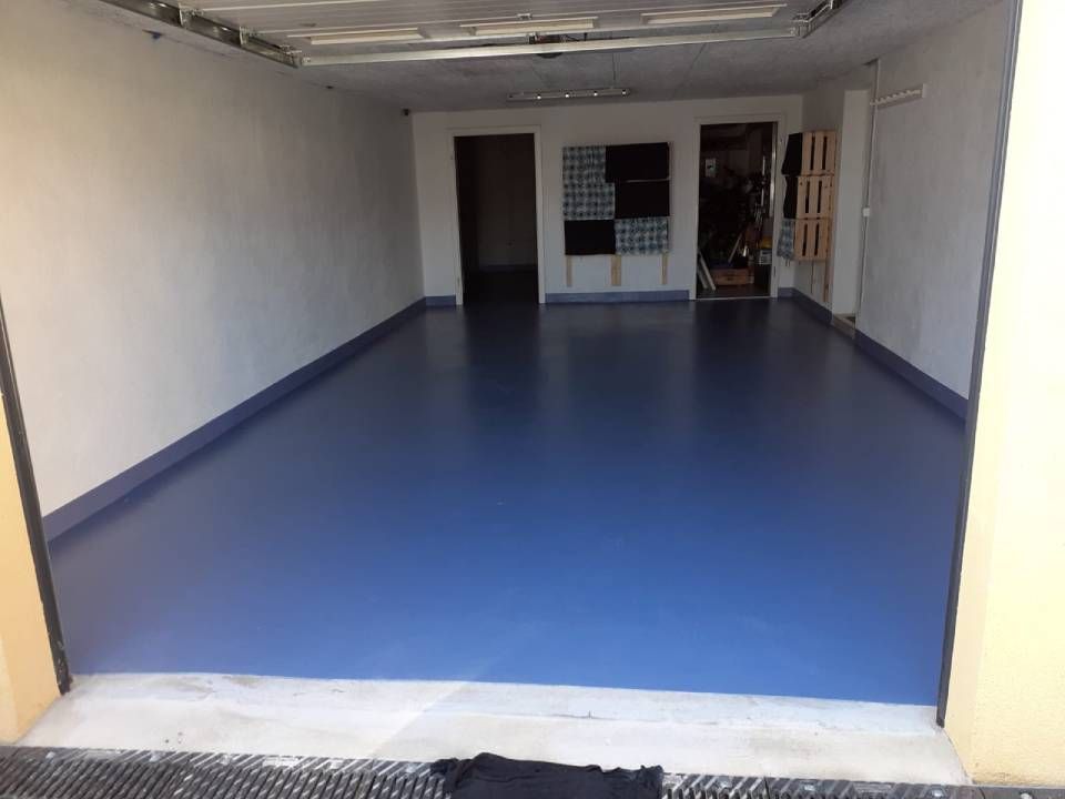 Une bande de peinture grise sur un mur blanc, avec un conduit électrique au-dessus et des débris en dessous.