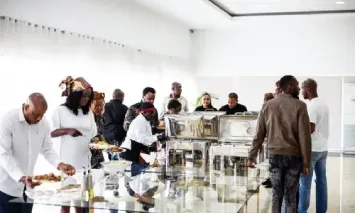 um grupo de pessoas está em volta de uma mesa em um bufê.