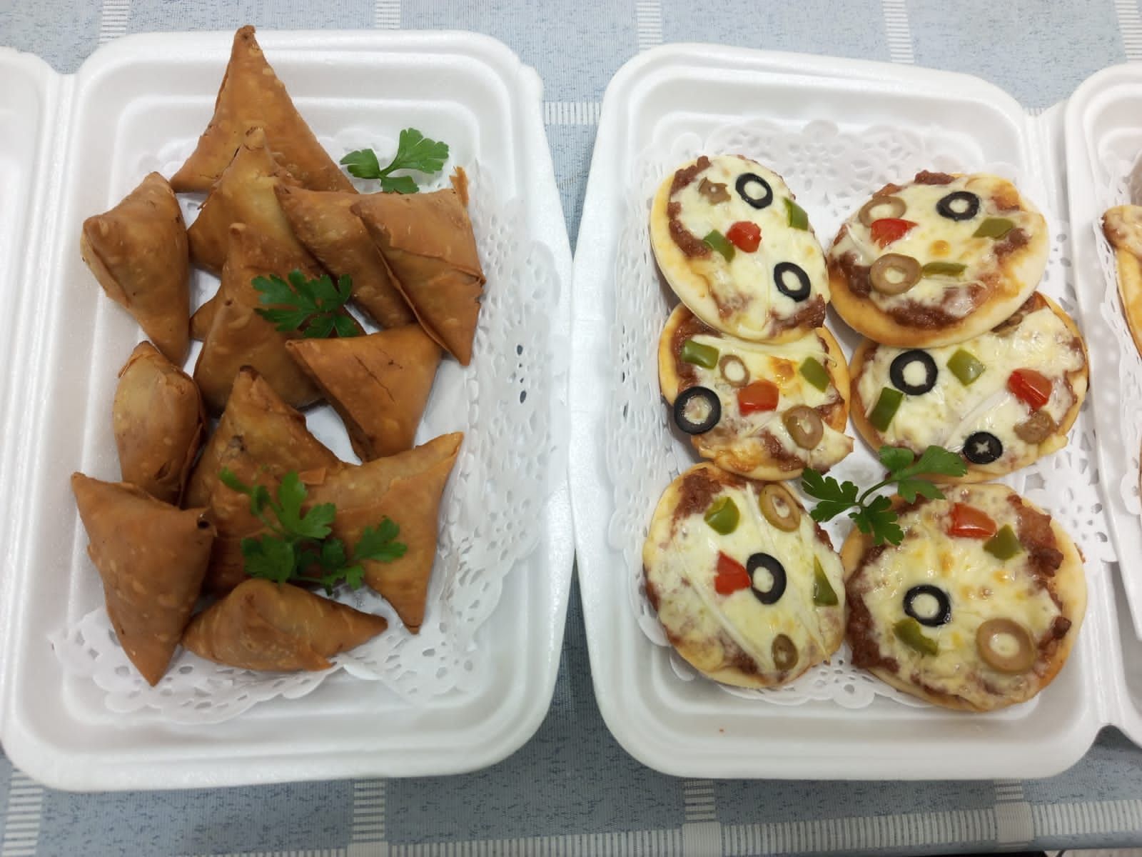 dois recipientes de isopor cheios de comida sobre uma mesa