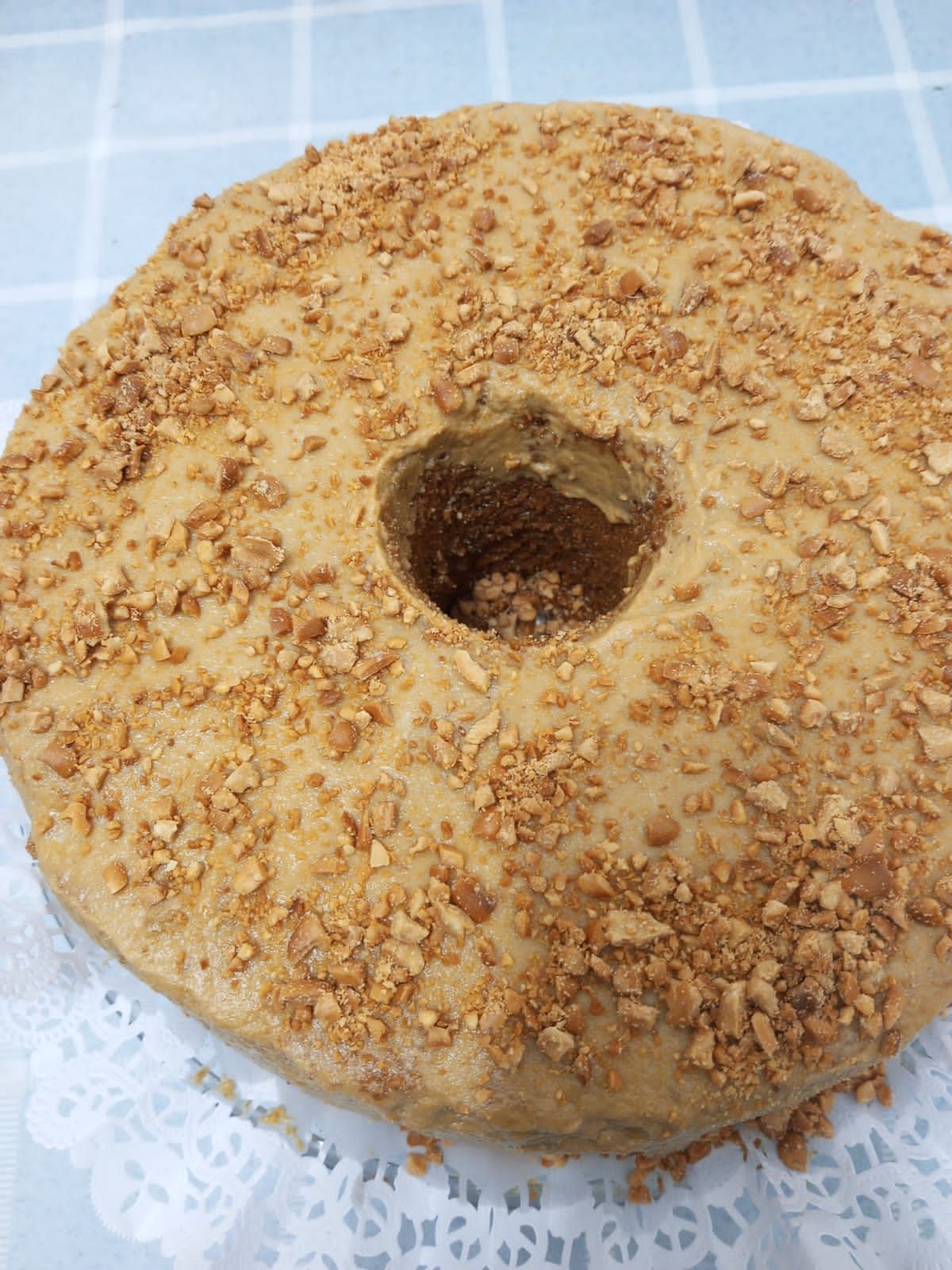 Um close de um donut com nozes sobre uma mesa.