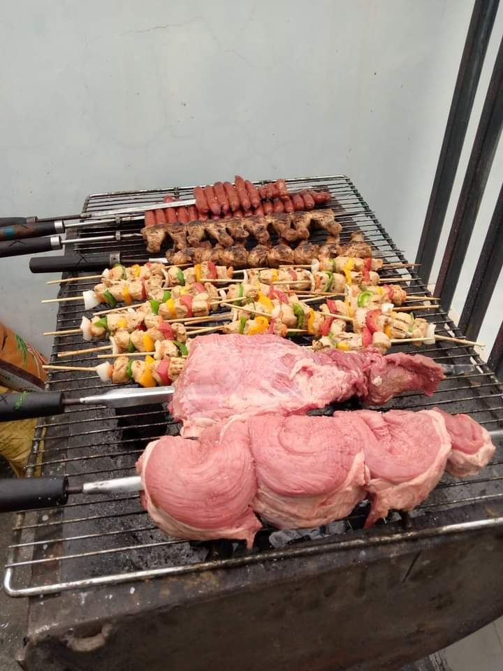 a bunch of meat and vegetables are cooking on a grill .