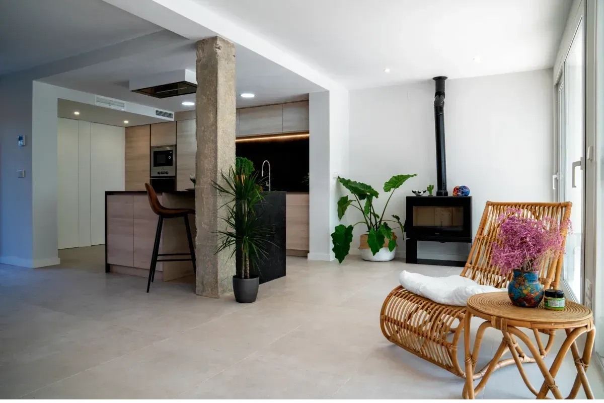 Una sala de estar con una silla de mimbre y una mesa.