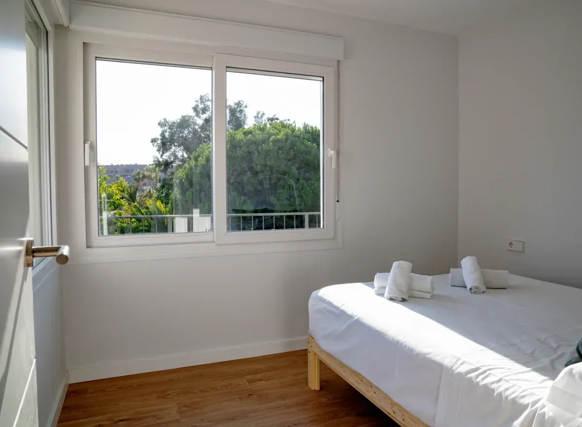 Un dormitorio con dos camas y una gran ventana.