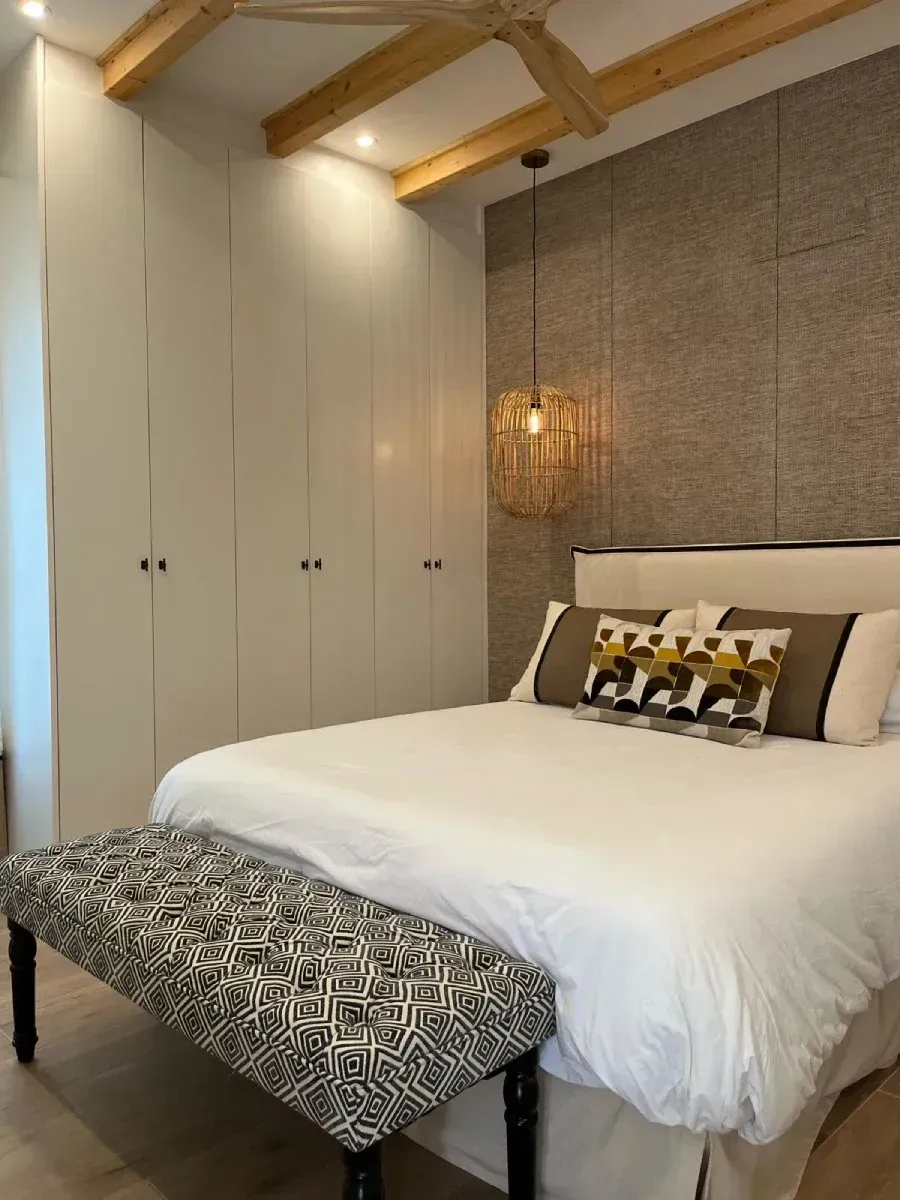 Un dormitorio con una cama grande y un banco.