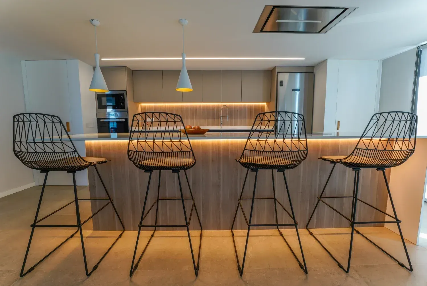 Una foto de una cocina con taburetes.