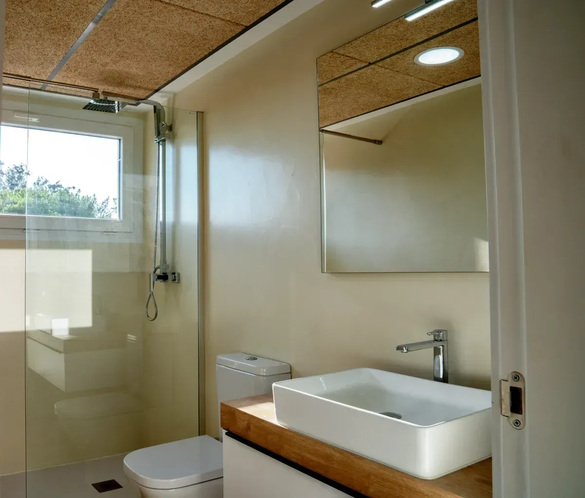 Un baño con inodoro, lavabo y espejo.