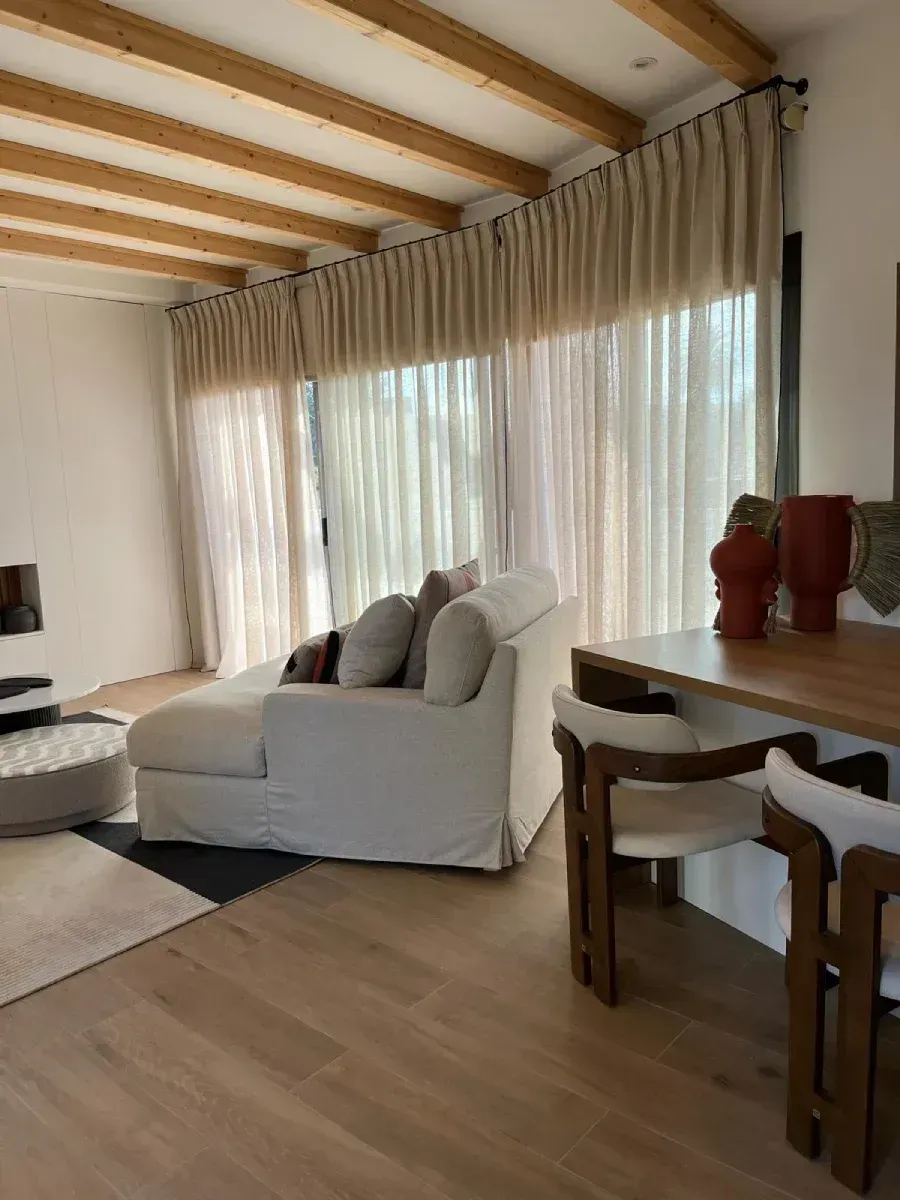 Una sala de estar con un sofá blanco y sillas.