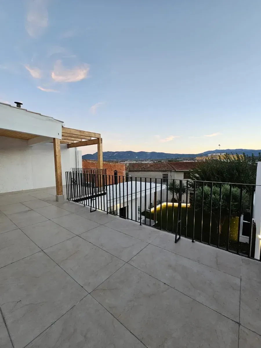Un balcón con vista a la ciudad y las montañas.