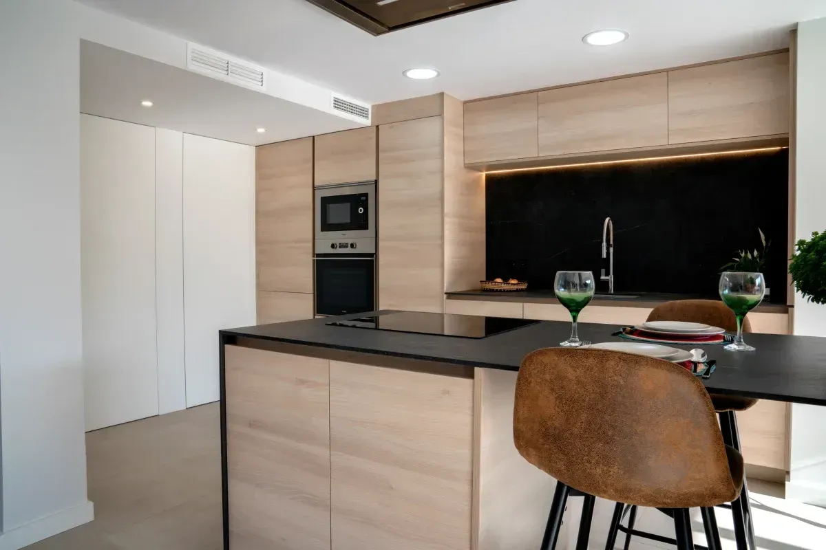 Una cocina con gabinetes de madera y una encimera negra.