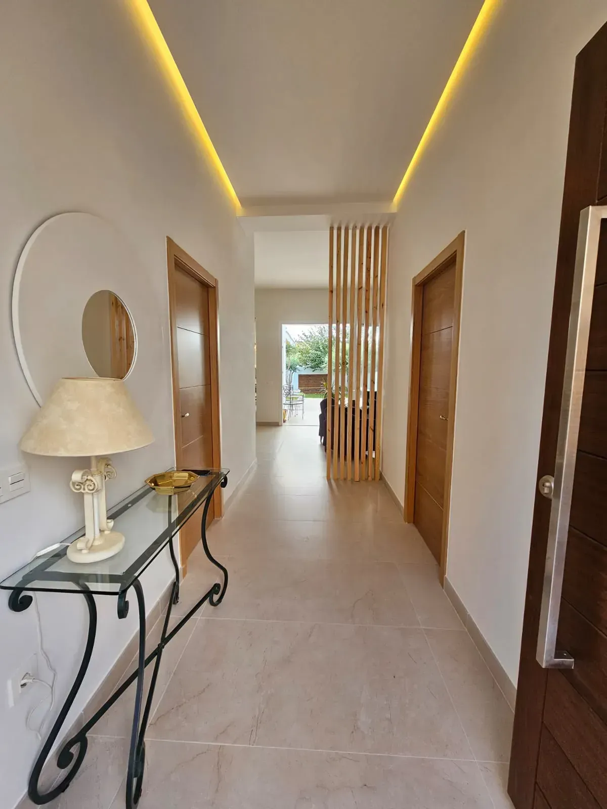Un pasillo con una mesa y una lámpara encima.