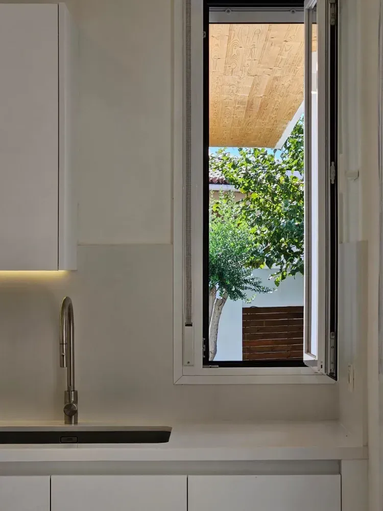 Una cocina con un fregadero y una ventana abierta.