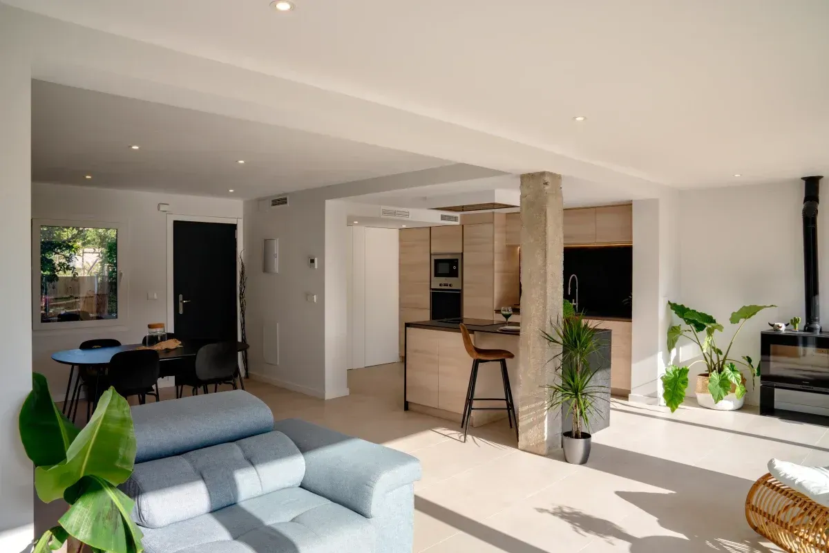 Una sala de estar con un sofá azul y una silla de mimbre.