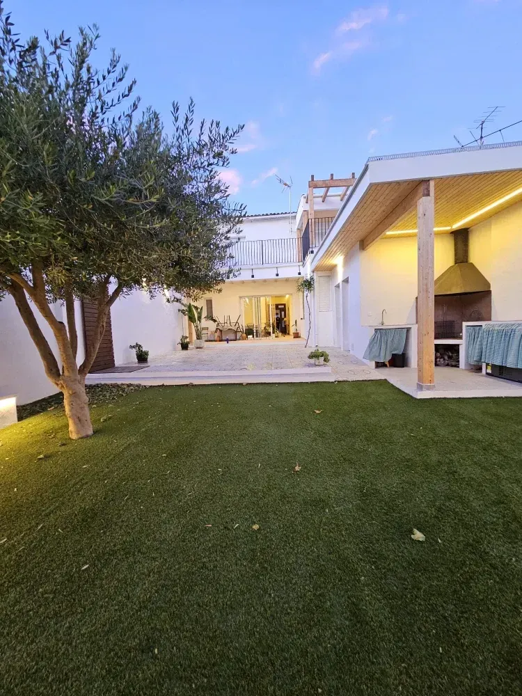 Una gran casa blanca con un amplio césped delante de ella.