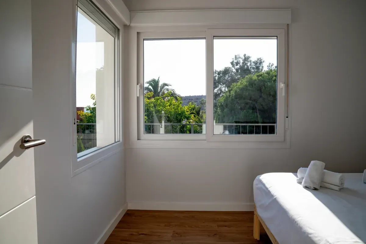 Un dormitorio con una cama y una ventana grande.