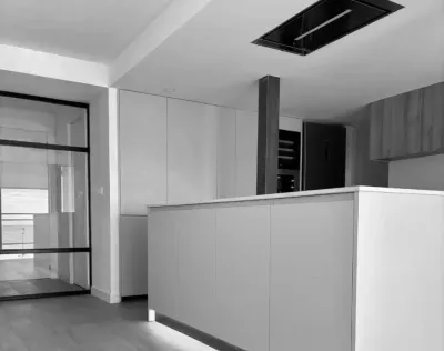 Una fotografía en blanco y negro de una cocina con un ventilador de techo.