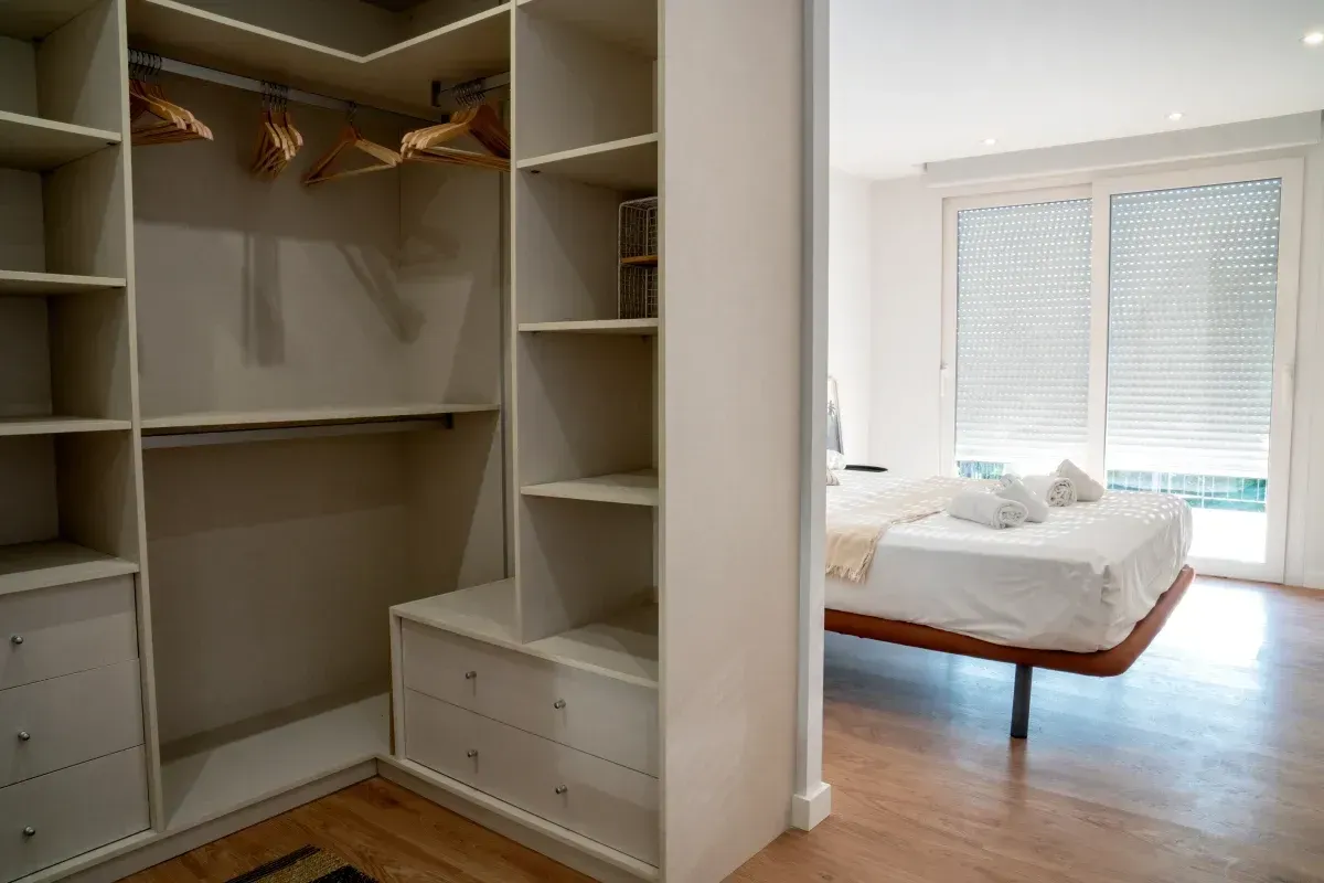 Un dormitorio con vestidor y una cama.