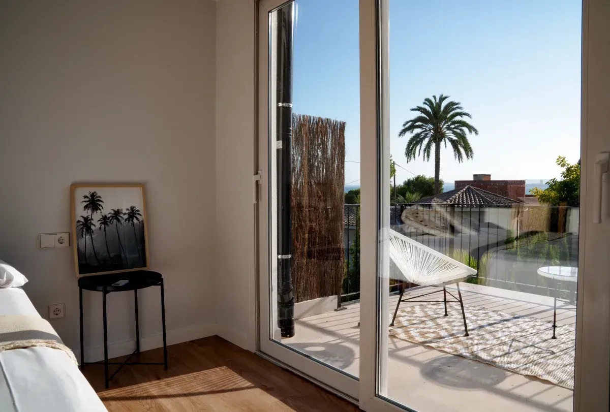 Un dormitorio con una puerta corrediza de vidrio que conduce a un balcón.
