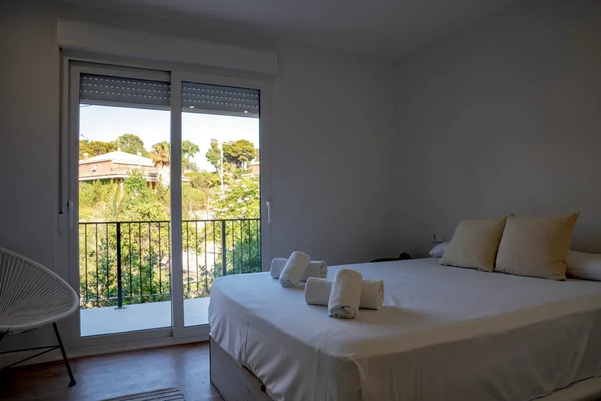 Un dormitorio con una cama grande y un balcón.