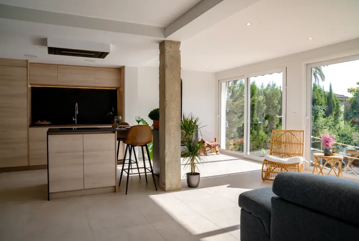 Una sala de estar llena de muebles y una cocina.