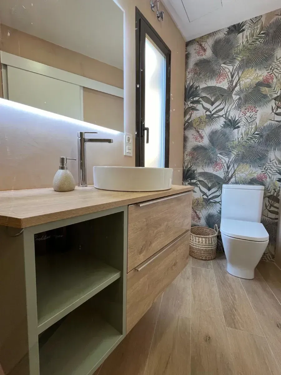 Un baño con lavabo, inodoro y espejo.